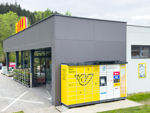 Modern parcel locker outside retail store for convenient package pickup in urban setting