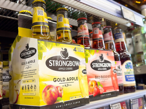 Variety of apple ciders and beers displayed in supermarket aisle