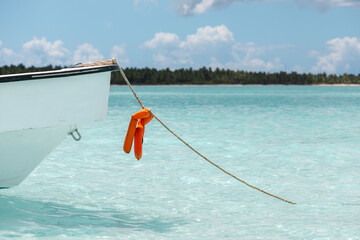 BOAT AT THE ANKER IN THE BLUE AND SUNNY BEACH BAY AT SAUNA ISLAND IN THE DOMINICAN REPUBLIC 