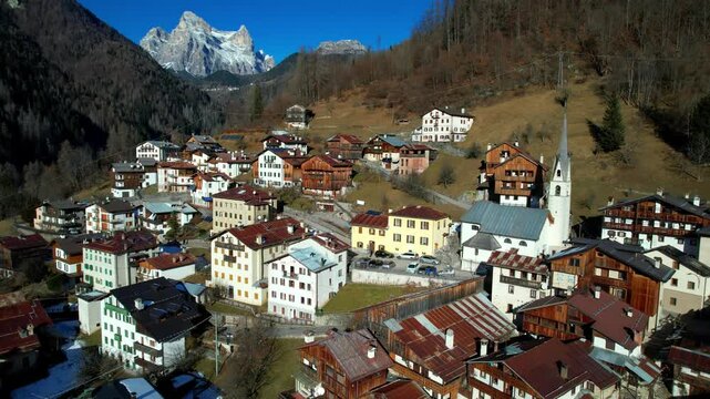 Aerial Reveal of Fornesighe Village in Val di Zoldo: Historic Church and Alpine Architecture near Cortina d'Ampezzo, Snowy Dolomites Peaks, 2026 Winter Olympic Region, Belluno Veneto Italy, 4K Drone
