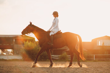 Woman rider jockey in helmet and white uniform preparing horse racing