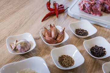 Spices arranged in bowls during cooking pilaf. Background of the kitchen interior.