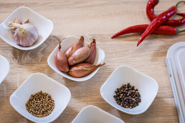 Spices arranged in bowls during cooking pilaf. Background of the kitchen interior.