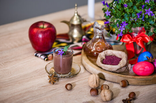 Traditional Azerbaijan sweet cuisine of holiday Nowruz: national dessert called Sumalak, assortment of nuts and colored egg. Selective focus.
