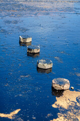 Concrete Blocks on asphalt Prime Coat Surface under Bright Sunlight