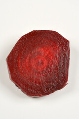 A halved cooked and peeled beetroot sits on a plain white plate