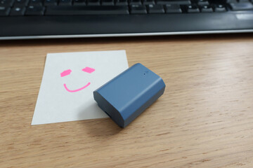 Bright blue battery next to the smiling hand drawn by hand, reflecting the happiness of extended power performance. Sticky notes