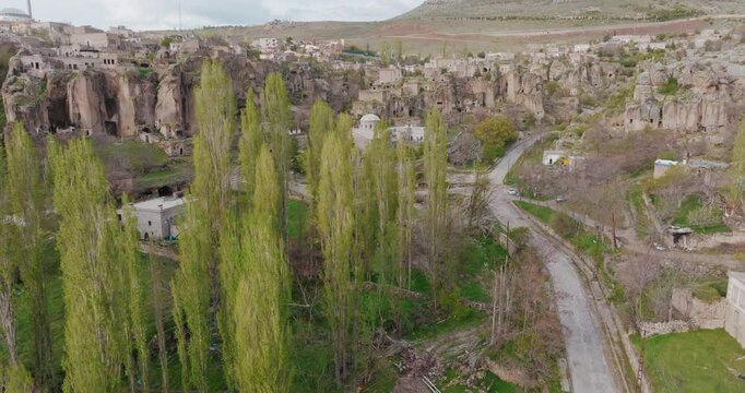 Drone shot in Monastery Valley, gliding towards the monastery. The volcanic rock formations, lush green trees and mystical atmosphere of the valley become more apparent as the drone gets closer.