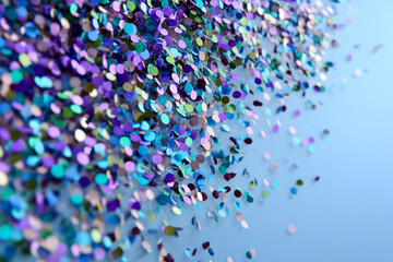 Pile of colorful glitter confetti on light-blue background, showcasing vibrant texture and festive feel, ideal for celebratory designs or party invitations, free space for text
