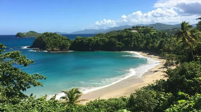 Scenic tropical beach cove with turquoise water, white sand, and lush green vegetation on the coast with distant mountains and scattered clouds.