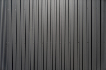 Black dark grey colored steel warehouse building exterior tiles close cup, steel pattern of exterior building