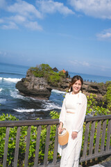 Woman Visiting Tanah Lot Temple in Bali on a Sunny Day