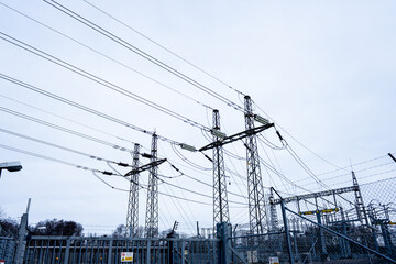 Electrical substation with high voltage power lines and fencing.