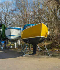 Colorful sailboats resting on dry dock.