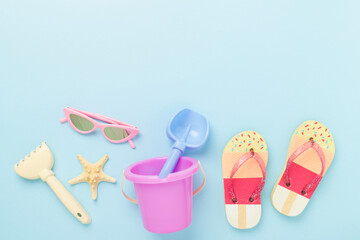 Children's flip flops and beach toys on color background,,top view