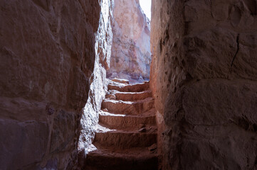 A narrow, dark stairway with a small opening in the wall