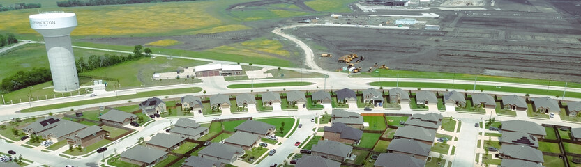 Panorama aerial view Princeton water tower in new home area, large construction site slab...