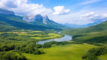Obraz premium Serene mountain valley with a winding river. Lush green landscape meets majestic peaks under a vibrant blue sky