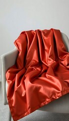 red blanket sitting on top of a white chair