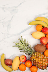 Detox diet and weight loss concept. Summer tropical fruits on marble table, source of vitamin C, store banner, healthy vegan products for healthy lifestyle, store advertisement.