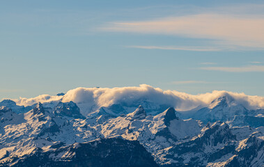 Obraz premium Majestic mountain range under a blue sky with clouds at sunset in a serene landscape