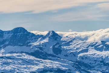 Snow-capped mountains under a clear sky showcasing their majestic peaks and tranquil beauty during...
