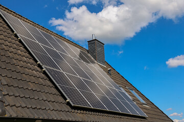 Photovoltaic panels producing renewable energy on rooftop against blue sky