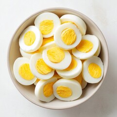Bowl filled with sliced eggs on white background