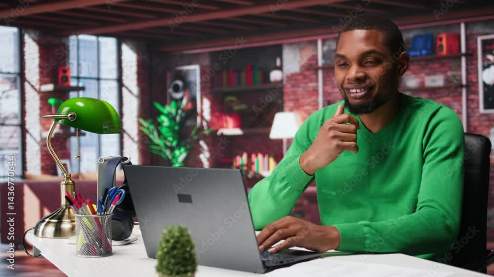 Poster black remote employee in home office using laptop for web assignments, preparing presentation slides