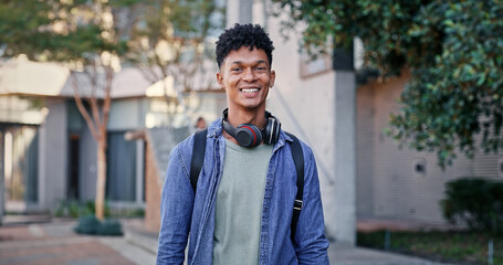 Man, happy and portrait at university for education, opportunity and pride for academic acceptance. Student, smile and headphones on campus for knowledge, development or college scholarship in Brazil