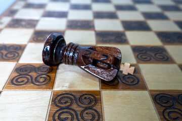 Fallen King on Decorative Chessboard – Symbol of Leadership Loss and Competition