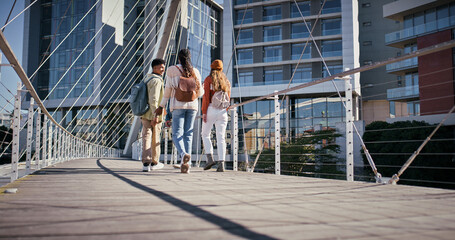 City, students and friends walking on bridge in city together with smile, solidarity and...