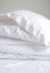 pile of white sheets and pillows on a bed