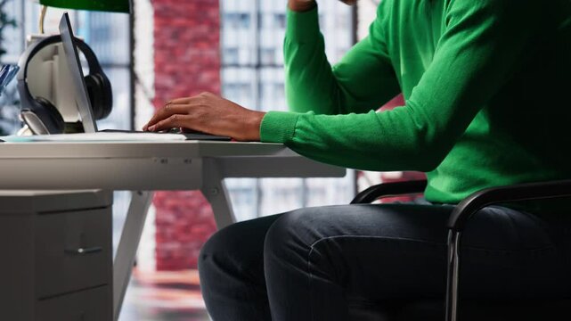 Black teleworker shaking his leg under the desk and acting unsettled, feeling anxious and tense while trying to meet task deadline at home office. Young adult feeling uneasy with ADHD. Camera A.