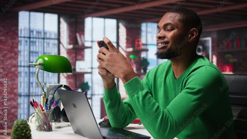 Aufkleber man at home using smartphone to compose social media posts, producing content as a freelancer. afric