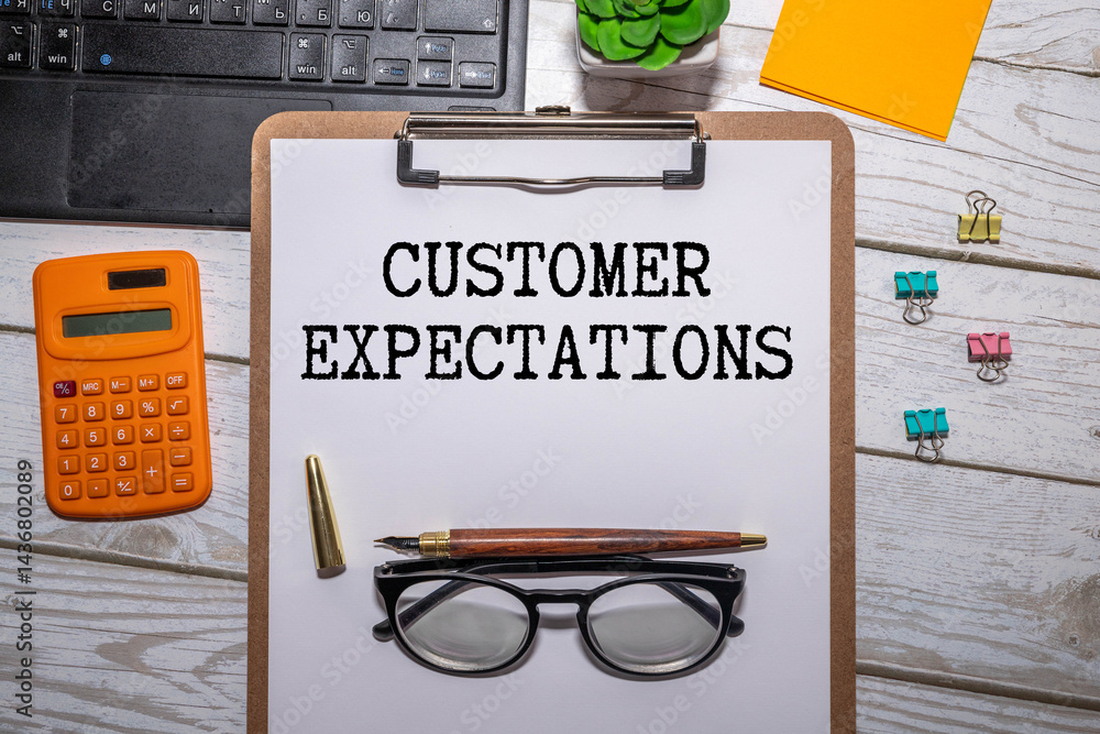 Poster text customer expectations on notepad with office tools.