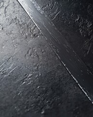 Fototapeta premium Close-up of a textured dark surface with a steel strip, showcasing contrast and detail.