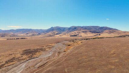 Naklejka premium Remote rural arid desert like valley McKenzies Pass near Dog Kennel corner Tekapo