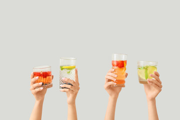 Many hands with infused water on light background