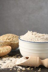 Brown rice and flour on grey table, closeup. Space for text