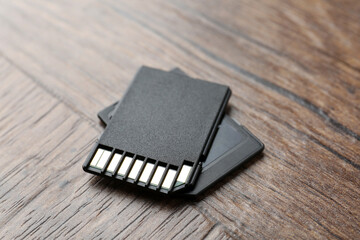 Two SD memory cards on wooden table, closeup