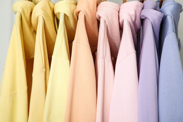 Stylish colorful hoodies on white background, closeup
