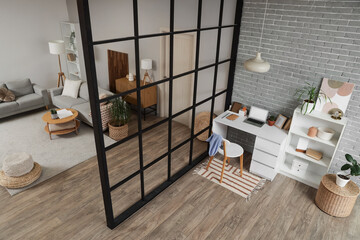Interior of studio apartment with sofas, folding screen and workplace