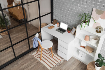 Interior of studio apartment with folding screen and workplace