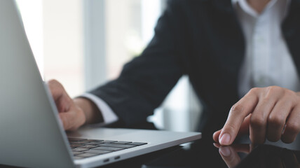 Close up of business woman hand working on laptop computer on office table, using mobile smart phone connecting the internet, search digital content, Business and technology concept