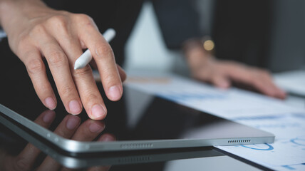 Close up, business man hand using digital tablet, working with financial report, business document on office table, data analysis