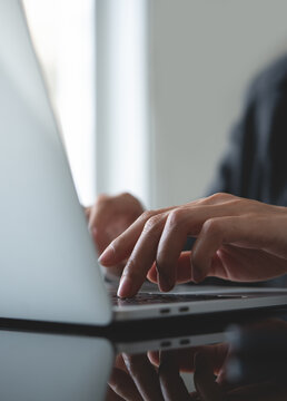 Close up , business woman typing on laptop computer on table. Businesswoman working on laptop computer, surfing the internet, vertical composition