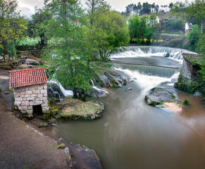 View over the Cavalos river in the village of Sevilha, municipality of Tábua, Portugal, with the beautiful set of watermills, the dam and the waterfalls.