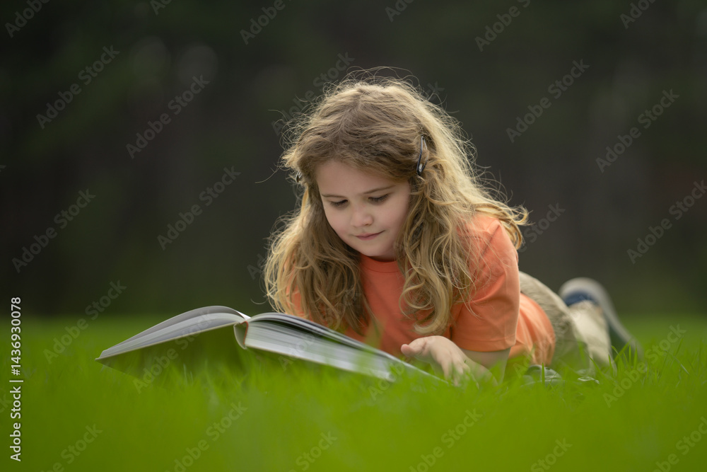 Poster child reading a book in the grass. kid enjoying a book story outdoors. child studying with book in t