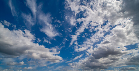 Sun shining through the puffy clouds. Sky view. Beautiful sunny sky. Background with clouds on blue...